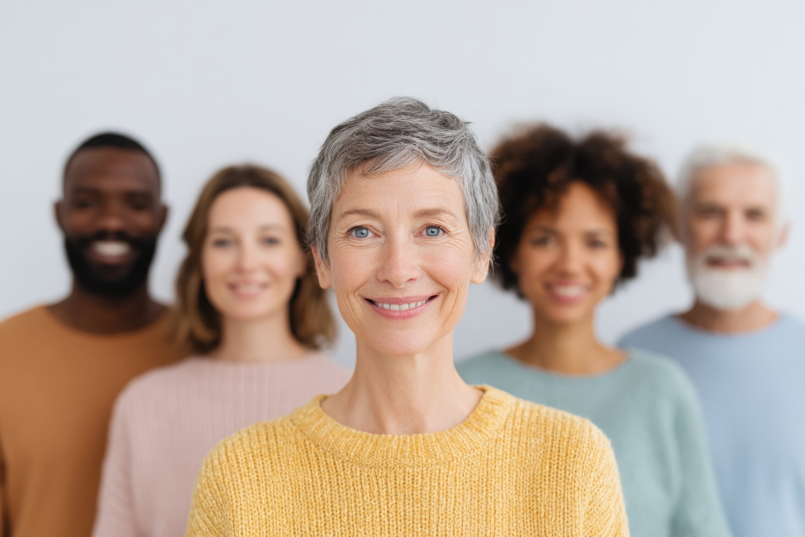 diverse group of people of various races and ages gathered for theater event posing against blurred backdrop